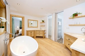 badezimmer mit zwei waschtischen über eck, holzboden in badezimmer